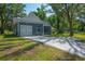 Charming exterior showcasing a garage, curved window, neat landscaping, and a smooth concrete driveway at 8453 Charleston Hwy, Walterboro, SC 29488