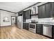 Open kitchen featuring stainless steel appliances, granite countertops, black cabinets, and views into the bathroom at 8453 Charleston Hwy, Walterboro, SC 29488