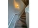 A carpeted staircase with white railing, well lit by a wall mounted sconce at 9410 Sweep Dr, Summerville, SC 29485
