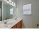 Well-lit bathroom with double vanity, large mirror, and a shower with curtain at 9682 Pebble Creek Blvd, Summerville, SC 29485