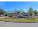 Impressive community entrance featuring a water feature, lush landscaping, and a grand main house at 9682 Pebble Creek Blvd, Summerville, SC 29485