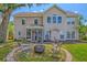 Two-story home's back exterior elevation with screened porch and firepit area at 9682 Pebble Creek Blvd, Summerville, SC 29485