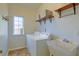 Well-lit laundry room features washer, dryer, utility sink, shelving and natural light at 9682 Pebble Creek Blvd, Summerville, SC 29485