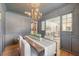 Elegant dining room with gray walls, chandelier, wainscotting and view to the living room at 1 Bossis Dr, Charleston, SC 29407