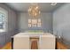 Elegant dining room with gray walls, wainscotting, chandelier and table set with decor at 1 Bossis Dr, Charleston, SC 29407