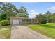 Charming brick home with an attached garage, a well-manicured lawn, and a long driveway at 1 Bossis Dr, Charleston, SC 29407