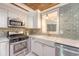Updated kitchen with stainless steel appliances, farmhouse sink and decorative tile backsplash at 1 Bossis Dr, Charleston, SC 29407