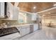 Bright kitchen with white cabinets, stainless appliances, green backsplash and wood plank ceiling at 1 Bossis Dr, Charleston, SC 29407