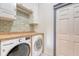 Well-lit laundry room featuring modern washer and dryer units with stylish backsplash at 1 Bossis Dr, Charleston, SC 29407