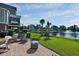 Backyard with brick patio, lounge chairs, palm trees, and a serene pond at 1003 Jervey Point Rd, Wando, SC 29492