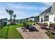 Backyard showcasing a well-manicured lawn, palm trees, pond, and patio at 1003 Jervey Point Rd, Wando, SC 29492