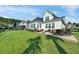 Backyard featuring lush lawn, covered porch, brick patio, and outdoor seating area at 1003 Jervey Point Rd, Wando, SC 29492