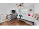 Comfortable bedroom with ceiling fan, wood floor, and a large window with white shutters for natural light at 1003 Jervey Point Rd, Wando, SC 29492