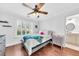 Comfortable bedroom with wood floor, ceiling fan and a window with white shutters for natural light and a bathroom en suite at 1003 Jervey Point Rd, Wando, SC 29492