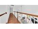 Bright hallway with wood floors and wood and white banister overlooking the living area with plenty of natural light at 1003 Jervey Point Rd, Wando, SC 29492