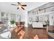 Spacious living room with hardwood floors, piano, and abundant light from large windows offering water views at 1003 Jervey Point Rd, Wando, SC 29492