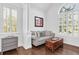 Sitting room area with hardwood floors, shuttered windows, light gray sofa and wood trunk at 1003 Jervey Point Rd, Wando, SC 29492