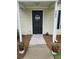 Close-up of the front door with a 'Welcome' decoration, flanked by potted flowers at 103 Dupont Way, Summerville, SC 29485