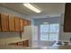 Another view of the kitchen featuring wooden cabinetry, white appliances, and tile flooring at 103 Dupont Way, Summerville, SC 29485