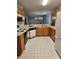 Functional kitchen with wooden cabinetry, white appliances, and tile flooring at 103 Dupont Way, Summerville, SC 29485