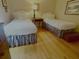 Cozy bedroom features twin beds, hardwood floors, and white comforters at 104 Silverhill Rd, Walterboro, SC 29488