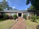 Charming brick home with a brick walkway, manicured bushes, and a double door entrance under a sunny sky at 104 Silverhill Rd, Walterboro, SC 29488