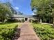 Charming brick home with a brick walkway, lush landscaping, and mature trees at 104 Silverhill Rd, Walterboro, SC 29488