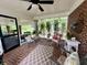 Screened porch featuring brick floors, a patterned rug, and wicker furniture at 104 Silverhill Rd, Walterboro, SC 29488