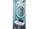 Cozy, bright blue bathroom with a classic pedestal sink, round mirror, and soft lighting at 108 Spanish Oaks Ln, Ladson, SC 29456