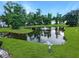Scenic pond view with a fountain surrounded by lush greenery and trees in a well-maintained community at 108 Spanish Oaks Ln, Ladson, SC 29456