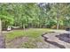 Spacious backyard with trees, a hammock, trampoline and playground slide at 110 Instructor Ct, Ladson, SC 29456
