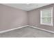 Bright bedroom featuring plush carpet, neutral walls, and a window with outdoor views at 110 Instructor Ct, Ladson, SC 29456