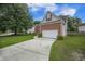 View of a brick and siding home with manicured yard and a long concrete driveway leading to a 2-car garage at 116 Holbrook Ln, Goose Creek, SC 29445