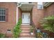 Close up view of a brick home's front door with potted plants on brick steps at 116 Holbrook Ln, Goose Creek, SC 29445