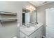 A bathroom with gray walls featuring dual sinks with a white vanity and shelving for storage at 124 Bright Meadow Rd, Summerville, SC 29483