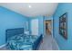 A bedroom with blue walls featuring a bed, nightstand, and view of a hallway with neutral-colored walls at 124 Bright Meadow Rd, Summerville, SC 29483