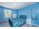 A bedroom with blue walls featuring a bed, nightstand, dresser, mirror, and a window with patterned curtains at 124 Bright Meadow Rd, Summerville, SC 29483