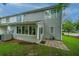 View of the backyard with gray siding, a sunroom addition, and a well-kept lawn at 1304 Elm Hall Cir, Summerville, SC 29483