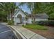 A view of the white-sided community clubhouse, showing a covered entrance, landscaping and mature trees at 1304 Elm Hall Cir, Summerville, SC 29483