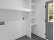 Bright laundry room features built-in shelving, grey tile flooring, and an exterior door at 1320 Bresee St, Charleston, SC 29412