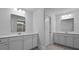 Bright bathroom featuring a double sink vanity, a large mirror, and tile flooring at 135 Lilac Grove Way, Summerville, SC 29486