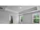 Bright bedroom with tray ceiling, view of trees, and an adjoining bathroom with glass-door shower at 135 Lilac Grove Way, Summerville, SC 29486