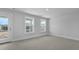 A bright, airy bedroom with carpet, two windows, and a door to a balcony at 135 Lilac Grove Way, Summerville, SC 29486