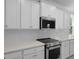 Stainless steel range and microwave, white cabinets, quartz countertops and tile backsplash at 135 Lilac Grove Way, Summerville, SC 29486