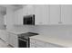 Close up of stove and microwave with white cabinets, countertop, backsplash and stainless steel appliances at 135 Lilac Grove Way, Summerville, SC 29486