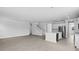 Open-concept living area with a kitchen island, gray plank flooring, and access to the staircase at 135 Lilac Grove Way, Summerville, SC 29486