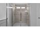 Beautifully tiled shower featuring a glass door enclosure and updated lighting at 135 Lilac Grove Way, Summerville, SC 29486