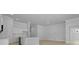 Open-concept kitchen features stainless steel appliances, white cabinets, and light wood flooring at 139 Lilac Grove Way, Summerville, SC 29486