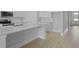 Bright kitchen features a large quartz countertop island, stainless steel appliances, and sleek, light wood floors at 139 Lilac Grove Way, Summerville, SC 29486