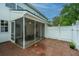Home's exterior with a screened-in porch and brick patio surrounded by a white fence at 1401 Elm Hall Cir, Summerville, SC 29483
